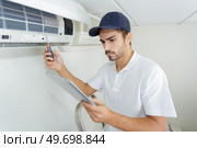 young contractor working carefully and seriously at clients office. Стоковое фото, агентство Ingram Publishing / Фотобанк Лори