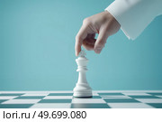 Рука передвигает белого шахматного короля. Стоковое AI-изображение, AI-художник Александр Жуков / Фотобанк Лори