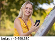cute woman is reading pleasant text message on mobile phone. Стоковое фото, агентство Ingram Publishing / Фотобанк Лори