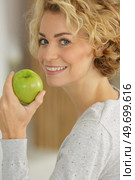 happy woman biting a green apple. Стоковое фото, агентство Ingram Publishing / Фотобанк Лори