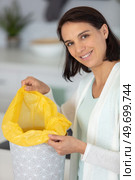 smiling woman changing garbage bags. Стоковое фото, агентство Ingram Publishing / Фотобанк Лори