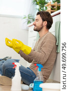 smiling young man househusband in apron rubber gloves meditating. Стоковое фото, агентство Ingram Publishing / Фотобанк Лори