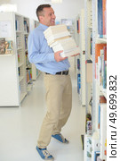 a librarian arranging the books. Стоковое фото, агентство Ingram Publishing / Фотобанк Лори