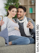 smiling beautiful couple hugging each other and looking at phone. Стоковое фото, агентство Ingram Publishing / Фотобанк Лори