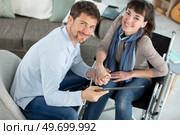 man and girlfriend in a wheelchair with a tablet. Стоковое фото, агентство Ingram Publishing / Фотобанк Лори