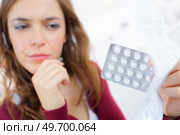 woman not sure about her medication. Стоковое фото, агентство Ingram Publishing / Фотобанк Лори