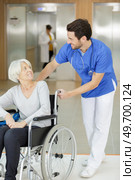 side view of social worker pushing wheelchair with senior woman. Стоковое фото, агентство Ingram Publishing / Фотобанк Лори