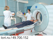doctor pushing buttons on mri tomograph. Стоковое фото, агентство Ingram Publishing / Фотобанк Лори