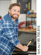 portrait of a male panel beater holding a rubber mallet. Стоковое фото, агентство Ingram Publishing / Фотобанк Лори