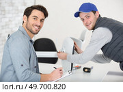 man assembling office chair under supervision. Стоковое фото, агентство Ingram Publishing / Фотобанк Лори
