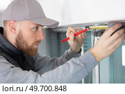 man measuring window prior to installation. Стоковое фото, агентство Ingram Publishing / Фотобанк Лори