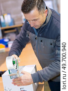 handyman taping packing case. Стоковое фото, агентство Ingram Publishing / Фотобанк Лори