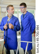 Man instructing trainee in use of blowtorch. Стоковое фото, агентство Ingram Publishing / Фотобанк Лори