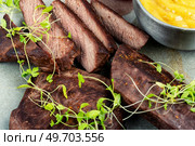 Roasted ostrich meat steaks with sauce and microgreens. African cuisine.. Osterich fillet steak. Стоковое фото, агентство Ingram Publishing / Фотобанк Лори