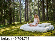 Young woman is resting on a mattress in summer forest. Girl is sleeping in the woods. Стоковое фото, агентство Ingram Publishing / Фотобанк Лори