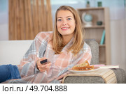 woman on sofa with fresh cake and remote watching tv. Стоковое фото, агентство Ingram Publishing / Фотобанк Лори