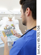 medical worker configures equipment in icu. Стоковое фото, агентство Ingram Publishing / Фотобанк Лори