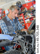 man replacing the spark plug. Стоковое фото, агентство Ingram Publishing / Фотобанк Лори