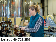 woman working on production oine of beer bottling plant. Стоковое фото, агентство Ingram Publishing / Фотобанк Лори