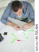 man assembling a drone seen from above. Стоковое фото, агентство Ingram Publishing / Фотобанк Лори