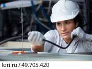 female electrician fixing ceiling wiring. Стоковое фото, агентство Ingram Publishing / Фотобанк Лори