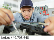 keen young serviceman repairing appliance. Стоковое фото, агентство Ingram Publishing / Фотобанк Лори