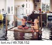 kids pday on the table while flooding in the kitchen. Photo and media photocombination. Стоковое фото, агентство Ingram Publishing / Фотобанк Лори