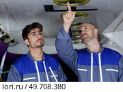 an engineer pointing under airplane. Стоковое фото, агентство Ingram Publishing / Фотобанк Лори