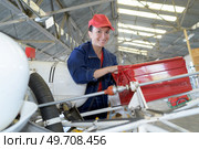 young female with wrench fixing part of jetliner. Стоковое фото, агентство Ingram Publishing / Фотобанк Лори