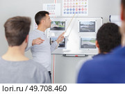 driving instructor in his class teaching trafic code to students. Стоковое фото, агентство Ingram Publishing / Фотобанк Лори