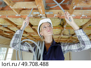 female electrician fixing ceiling lighting. Стоковое фото, агентство Ingram Publishing / Фотобанк Лори