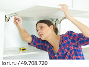 woman fitting a kitchen furniture. Стоковое фото, агентство Ingram Publishing / Фотобанк Лори