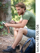 cheerful male tourist preparing wood. Стоковое фото, агентство Ingram Publishing / Фотобанк Лори