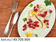 Cod fillet without skin cooking with red currants. Cod fish, white fish on wooden table.. Codfish loin baked with berries. Стоковое фото, агентство Ingram Publishing / Фотобанк Лори