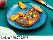 Diet baked veal steak with peach. Juicy meat steak with peach. Стоковое фото, агентство Ingram Publishing / Фотобанк Лори