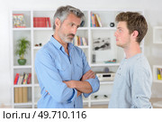 Man looking sternly at teenager. Стоковое фото, агентство Ingram Publishing / Фотобанк Лори