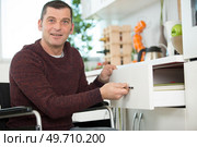 disabled man in wheelchair open drawer. Стоковое фото, агентство Ingram Publishing / Фотобанк Лори