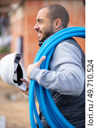 portrait of a smiling worker carrying corrugated conduit. Стоковое фото, агентство Ingram Publishing / Фотобанк Лори