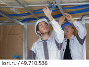 people are utting steel pipe. Стоковое фото, агентство Ingram Publishing / Фотобанк Лори
