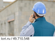 male builder foreman on building site using phone and plans. Стоковое фото, агентство Ingram Publishing / Фотобанк Лори