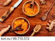 Raw turmeric root and turmeric or curcuma powder on a retro wooden background. Homeopathic herbs.. Turmeric root and turmeric powder, medicine herb. Стоковое фото, агентство Ingram Publishing / Фотобанк Лори