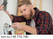 professional electrician man is fixing a water heater. Стоковое фото, агентство Ingram Publishing / Фотобанк Лори
