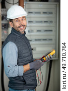 electrician using electric actuator equipment in fuse box. Стоковое фото, агентство Ingram Publishing / Фотобанк Лори