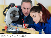 young woman working at carpenter shop with her teacher. Стоковое фото, агентство Ingram Publishing / Фотобанк Лори