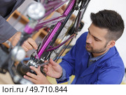 Trainee mechanic working on bicycle. Стоковое фото, агентство Ingram Publishing / Фотобанк Лори