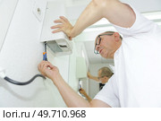 a man installing hand dryer. Стоковое фото, агентство Ingram Publishing / Фотобанк Лори