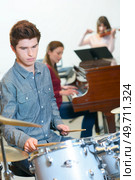 young drummer with drumsticks in a music class. Стоковое фото, агентство Ingram Publishing / Фотобанк Лори