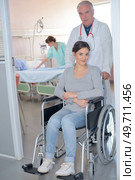 Doctor wheeling patient in wheelchair. Стоковое фото, агентство Ingram Publishing / Фотобанк Лори