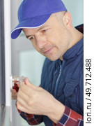 professional electrician stripping wire ends with cutter indoors. Стоковое фото, агентство Ingram Publishing / Фотобанк Лори