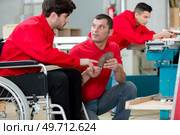 disabled worker in wheelchair in factory on the machine. Стоковое фото, агентство Ingram Publishing / Фотобанк Лори